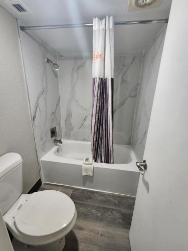 a bathroom with a toilet and a tub and a sink at La Quinta Inn by Wyndham Bossier City in Bossier City