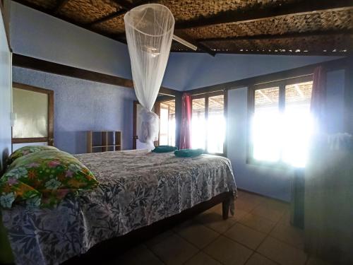 a bedroom with a bed in a room with windows at Te Nahe Toetoe - New Look 2025 in Parea