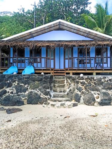 a house on the beach with stairs in front of it at Te Nahe Toetoe - New Look 2025 in Parea