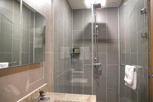a bathroom with a shower with a glass door at Ramada by Wyndham Gangwon Sokcho in Sokcho