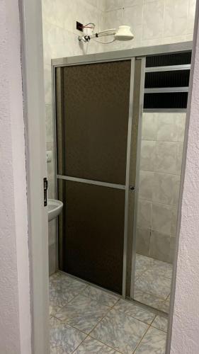 a glass shower door in a bathroom with a toilet at Linda Chácara com Piscina Churrasqueira e Wi-FI in Mairinque