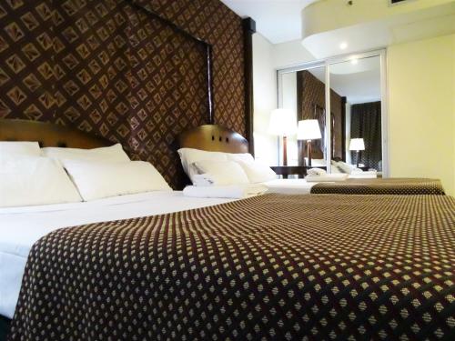 um quarto de hotel com duas camas e um espelho em Abasto Hotel em Buenos Aires