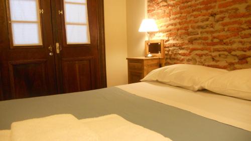 a bedroom with a bed and a brick wall at Posada Gotan in Buenos Aires
