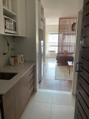 a kitchen with white counter tops and a hallway at Obelisco Haus in Buenos Aires