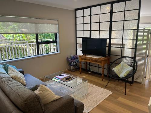 a living room with a couch and a table at Sea-batical Retreat in Auckland