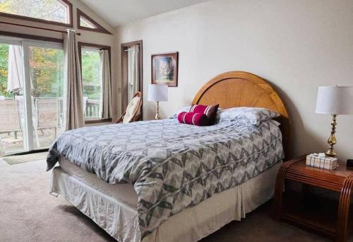 a bedroom with a large bed with a wooden headboard at 5-Bedroom Lakefront, private beach wifi AC boat & in Tobyhanna
