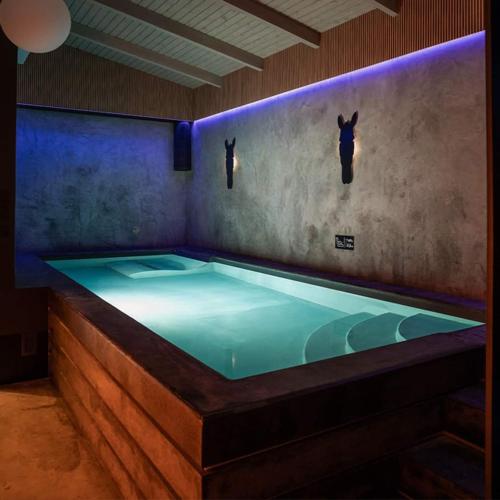 a jacuzzi tub in a room with two bulls on the wall at Salio Equisport Resort in Stryków