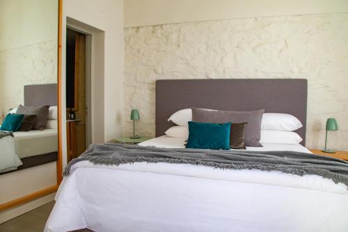 a bedroom with a large white bed with blue pillows at Casa Lahusen in Colonia del Sacramento