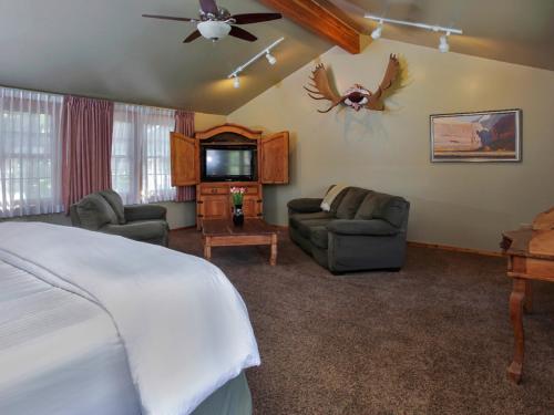 a bedroom with a bed and a couch and a tv at Flanigan`s Resort and Spa in Springdale