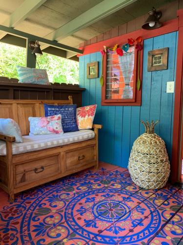 a room with a bed and a blue wall at ROMATIC WATERFALL CABIN in the Rainforest in Honokaa