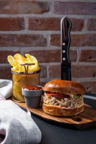 a sandwich on a cutting board with a knife at Salio Equisport Resort in Stryków
