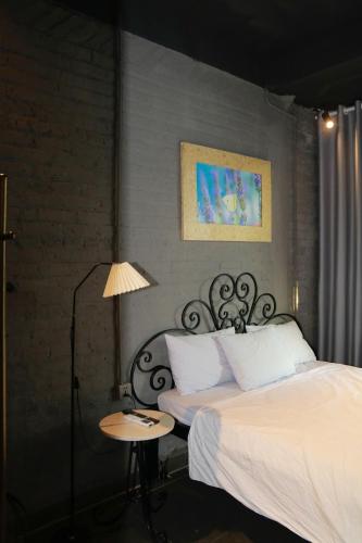 a bedroom with a bed and a table with a lamp at Lavender Hotel 202 - Nam Đuống, Thượng Thanh, Long Biên in Ái Mộ