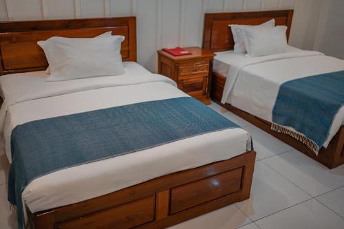 a bedroom with two beds and a night stand with tworams at Montagne Regency in Kampot