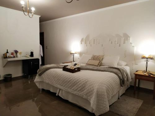 ペネドにあるLe Garden Pousada Boutiqueの白い壁の大きなベッドのある寝室