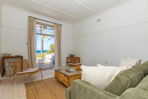 a living room with a couch and a table at Davley House, St James Kalk Bay in Cape Town
