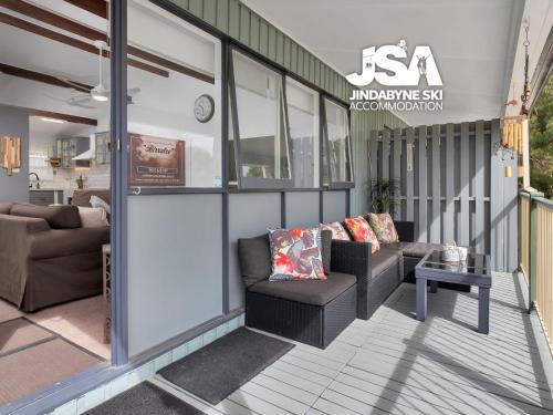 a screened porch with two chairs and a table at Birralee 1 in Jindabyne