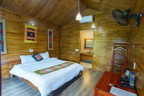 a bedroom with a bed in a wooden room at Bac Ha Lodge Retreat in Bắc Hà