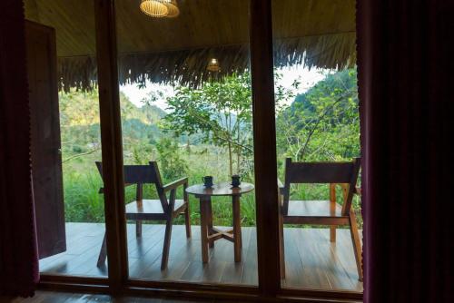 a room with a table and two chairs and a window at Bac Ha Lodge Retreat in Bắc Hà