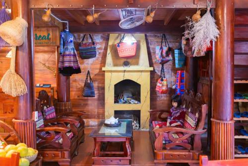 a child sitting in a chair in a room with a fireplace at Bac Ha Lodge Retreat in Bắc Hà