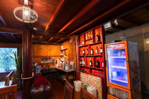 a bar with a refrigerator and a counter with alcohol at Bac Ha Lodge Retreat in Bắc Hà