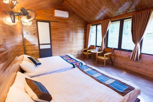 a bedroom with two beds in a wooden cabin at Bac Ha Lodge Retreat in Bắc Hà