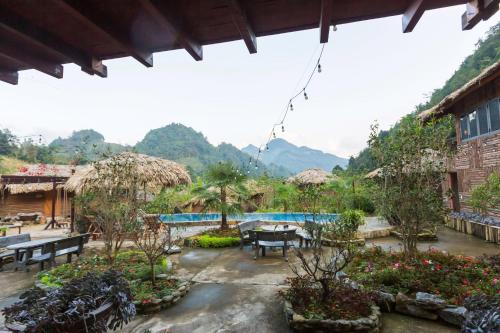 a patio with a table and benches and a pool at Bac Ha Lodge Retreat in Bắc Hà