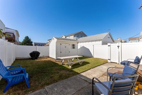 a backyard with chairs and a picnic table and a fence at 108 W 20Th Ave, Unit 2 in North Wildwood