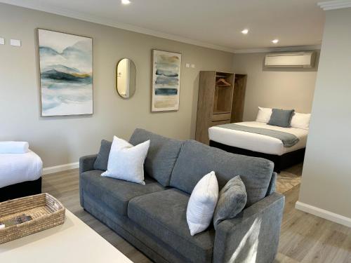a living room with a couch and two beds at Hunter Oasis in Morpeth