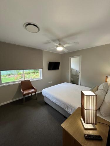a bedroom with a bed and a chair and a window at Hunter Oasis in Morpeth