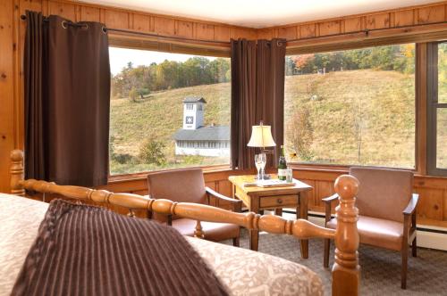 a bedroom with a bed and a desk and a window at Whitneys Inn at Black Mountain in Jackson