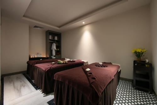 a room with two beds with brown sheets on them at MAY DE VILLE Crown Hotel in Hanoi