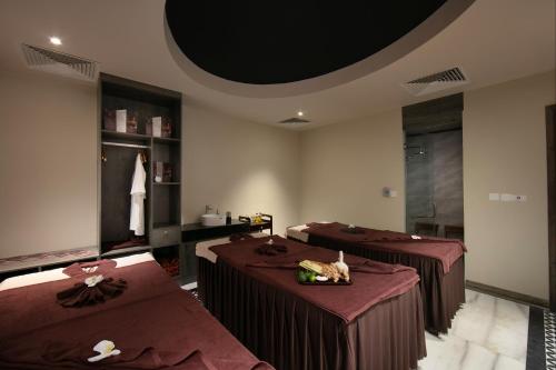a room with three beds with red sheets and a room with at MAY DE VILLE Crown Hotel in Hanoi