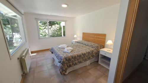 a small bedroom with a bed and a window at Sakura No Ie in San Carlos de Bariloche