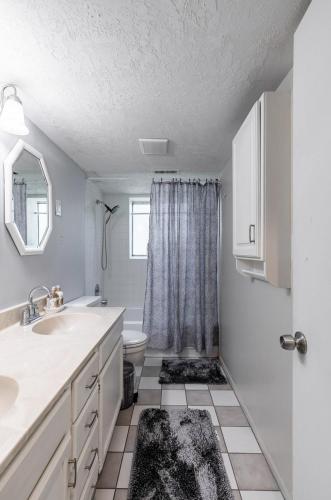 サンディにあるBeautiful Home with Mountain Viewsの洗面台とトイレを備えた白いバスルーム