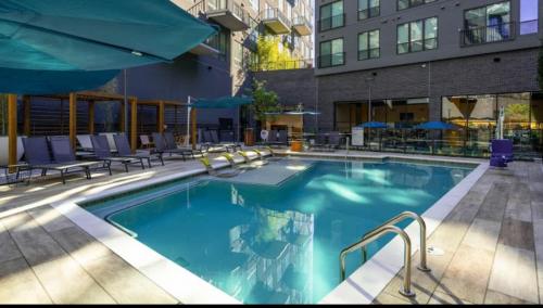 a large swimming pool with chairs and a building at central located Modern west Midtown suite in Atlanta