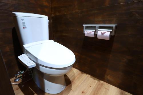 a bathroom with a toilet and two rolls of toilet paper at ゲストハウスAgain in Hitoyoshi