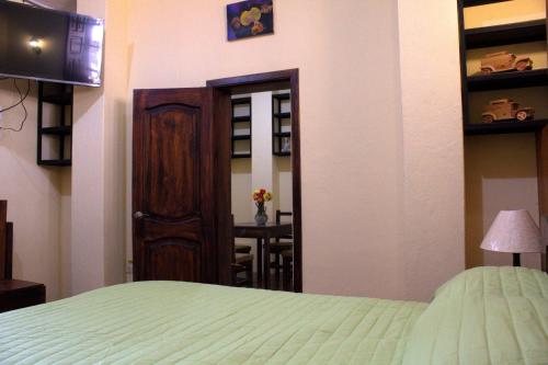 a bedroom with a bed and a door and a table at Apart Hotel Loma Chica Quito in Quito