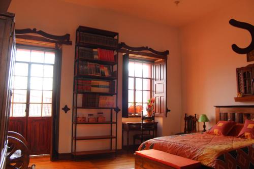 a bedroom with a bed and a book shelf with books at Apart Hotel Loma Chica Quito in Quito