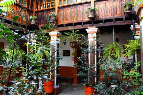 a building with a bunch of potted plants at Apart Hotel Loma Chica Quito in Quito