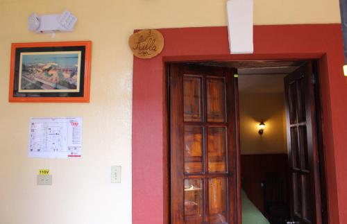 a room with a red and white wall with a door at Apart Hotel Loma Chica Quito in Quito