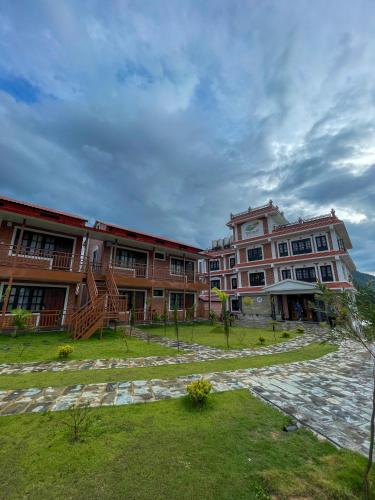 a large building with a grass yard in front of it at Thumki Resort, Balthali in Panauti