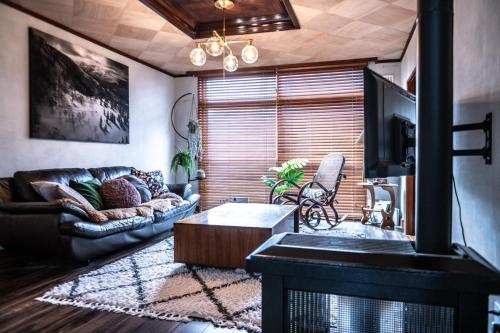 a living room with a couch and a coffee table at NIKI HOUSE -Yoichi 貸切一軒家 in Kurokawamachi