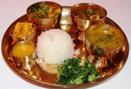 a plate of food with rice broccoli and other foods at Thumki Resort, Balthali in Panauti