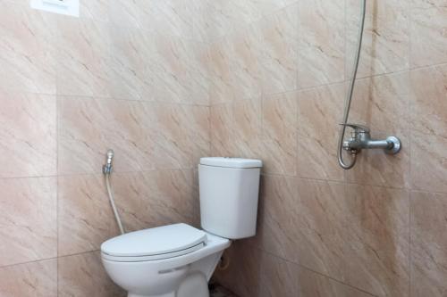 a bathroom with a toilet and a shower at RedDoorz Syariah at Penginapan Queen Sungai Penuh in Sungaitutung