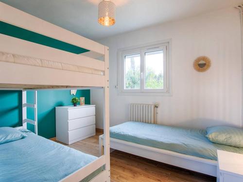 une chambre avec deux lits superposés et une fenêtre dans l'établissement Maison de plain-pied avec jardin privé et terrasse à Cabourg - FR-1-788-40, à Cabourg