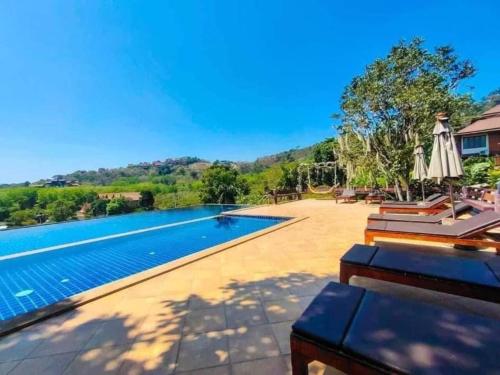 a swimming pool with a view of the mountains at Puteri Lanta Family Villas in Ko Lanta