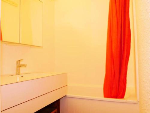 La salle de bains est pourvue d'un lavabo et d'un rideau de douche rouge. dans l'établissement Résidence Les Roches - deux pièces à proximité des pistes MAE-6331, à Aime La Plagne