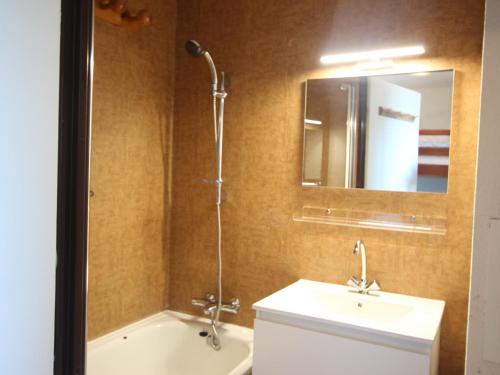 a bathroom with a sink and a tub and a mirror at Studio confortable à Chamrousse avec balcon et cuisine équipée - FR-1-340-283 in Chamrousse