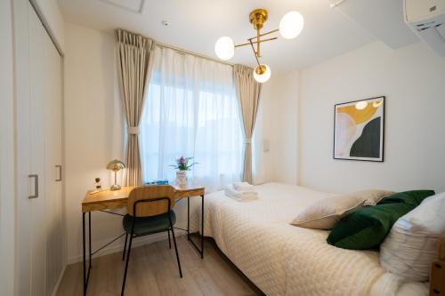 a bedroom with a desk and a bed and a window at Ken's Place Omotesando in Tokyo