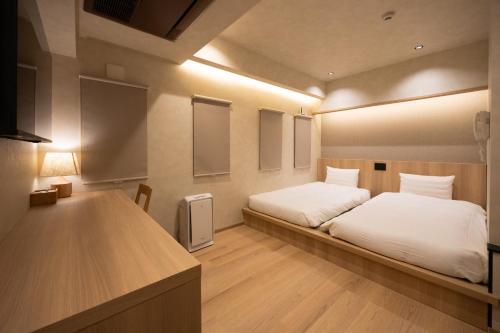 a bedroom with a bed with white sheets and lights at Hotel Paul House in Tokyo